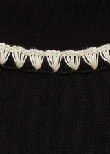 Camiseta a rayas horizontales blancas y negras, de manga corta y cuello redondo con ribetes negros.