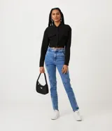 Camisa cropped negra de viscosa con cuello camisero, manga larga con puños abotonados, bolsillos de parche en el pecho, cierre frontal con botones ocultos, recortes laterales y elástico en la espalda.