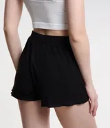 Short de pijama negro de ribana con cintura elástica y botones decorativos.