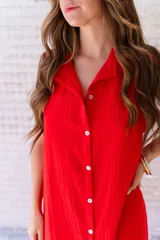 Camisola roja tipo vestido camisero, de corte midi, con cuello camisero, abotonada al frente y con abertura en el ruedo.