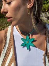 Collar con dije en forma de flor pintado a mano en color verde agua con detalles de mostacillas en relieve color naranja y rosa.