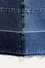 Pantalón de jean de tiro medio con cinco bolsillos, corte wide leg y detalle de tejido con lavado lateral combinado.