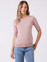 Buzo tejido en hilado fino, color rosado, con cuello redondo y mangas cortas.