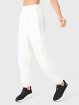 Pantalón de buzo negro de tela suave, con cintura elástica, bolsillos laterales y traseros, y elástico en los tobillos.