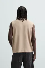 Camiseta sin mangas color beige con estampado de caballos en color borgoña.