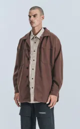 Chaqueta marrón de paño con cuello clásico, cierre frontal con botones, dos bolsillos de parche en el pecho y corte holgado.