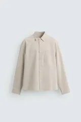 Camisa de manga larga color beige con rayas verticales finas, cuello italiano, corte regular fit, bolsillo de parche en el pecho y cierre frontal con botones.