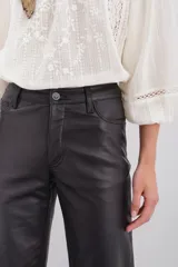 Pantalón de cuero ovino color negro, de corte jeanero con calce oxford y tiro medio. Tiene acceso delantero con botón metálico y cierre, y bolsillos delanteros y traseros.
