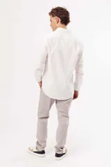 Camisa blanca de corte slim fit, manga larga y cuello clásico. Cierre frontal con botones.
