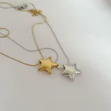 Collar dorado con dije de estrella inflada.