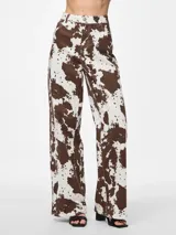 Pantalón de jean ancho con estampado de cebra en tonos marrones y blancos.