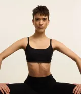 Top deportivo negro de corte bralette, con escote recto y breteles finos.