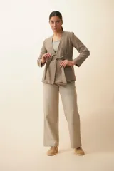 Chaqueta corta color beige, entallada, con escote en V, manga larga y cierre frontal con lazo fijo. Confeccionada en lana fina sin teñir, con bolsillos escondidos y terminaciones enviadas. Hecha 100% en Uruguay.