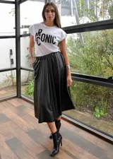 Falda midi negra de cuero sintético, corte evasé y cintura elástica.