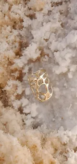 Anillo dorado con diseño abstracto con aberturas.