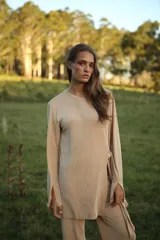 Blusa color beige de mangas largas con abertura en los puños y lazo lateral.