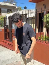 Camiseta negra de manga corta con estampado en la espalda del logo de Brixton y una flor de hibisco.