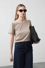 Remera de tejido acanalado color beige, de manga corta con terminación de puntilla.