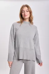 Sweater de punto color gris claro, de cuello alto y corte holgado.