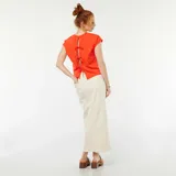 Camiseta roja de manga corta con espalda abierta y lazos decorativos.