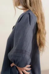 Vestido largo rojo con escote en V, mangas abullonadas con elástico en el puño y detalle de pespunte en contraste. Presenta un canesú con efecto punto smock y bolsillos laterales.