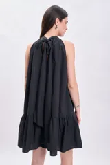 Vestido corto negro con cuello halter y falda con volados.