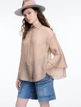 Camisa negra de lyocell y poliamida, con cuello clásico, mangas largas acampanadas con volados y cierre frontal con botones.