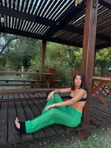 Pantalón tejido de punto color verde brillante, de tiro bajo y calce holgado, con cordón ajustable en la cintura.