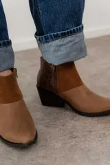 Bota corta de cuero color marrón con paneles de gamuza y cuero texturizado.