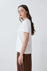 Remera blanca de algodón con cuello redondo y bordado de flores en el frente.