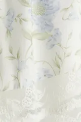 Short blanco con estampado floral celeste y verde, tiro alto, corte holgado, elástico en la cintura y ribete de encaje en el bajo.