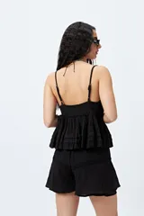 Short blanco de tela liviana con textura arrugada y detalles de encaje en el ruedo. Presenta cintura elástica.