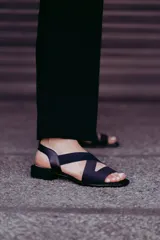 Sandalia negra de neopreno con tiras cruzadas y plantilla de cuero.
