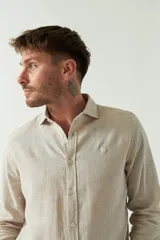 Camisa de manga larga color amarillo claro, confeccionada en lino y algodón, corte semi slim y logo bordado.