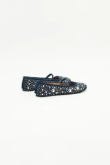 Bailarinas planas de gamuza azul marino con tira de terciopelo en el empeine. El cuerpo del zapato está completamente cubierto con apliques y bordados de perlas y cristales en tonos blancos y dorados.