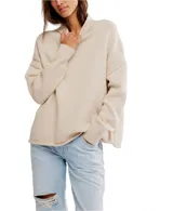 Suéter tejido color beige claro, de corte oversized y cuello alto con solapa. Presenta mangas largas con puños anchos y dobladillos enrollados.