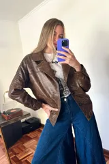 Campera bomber de cuero marrón veteado con cuello desmontable de corderito crudo y detalle de pasamanería en las mangas.