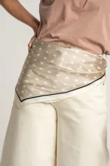 Pañuelo cuadrado de seda color beige con lunares blancos y borde negro.
