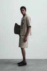 Bermuda color arena de tejido interlock de algodón con elasticidad, corte relaxed fit, cintura elástica ajustable con cordón interior, bolsillos laterales y bolsillo trasero de plastrón.