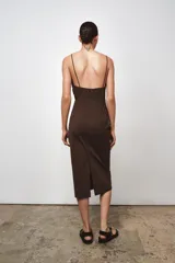 Vestido midi marrón con cuello halter y tirantes finos. Presenta detalle de tejido drapeado y cierre con cremallera oculta en la costura.
