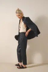 Pantalón babucha de cuero ovino color negro, con bolsillos en el frente, cintura elastizada y tira de ajuste con terminales metálicas.