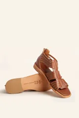 Sandalia de cuero color chocolate con tiras entrecruzadas y cierre trasero con cremallera.