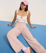 Pantalón femenino de sarga color rosa pálido, modelo baggy de cintura mediana, con trabillas, cierre tradicional y cinco bolsillos. Confeccionado con algodón certificado BCI.