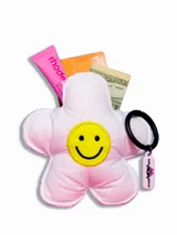 Monedero pequeño en forma de flor de tela acolchada color rosa pálido con carita sonriente bordada en amarillo. Incluye llavero con dije rosa.