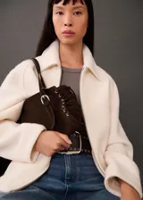 Chaqueta marrón de tejido mezcla de lana con forro interior, cuello camisero, cierre delantero con cremallera, dos bolsillos laterales y diseño oversize.