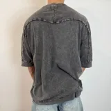 Remera gris con efecto lavado, corte oversize y mangas 3/4.