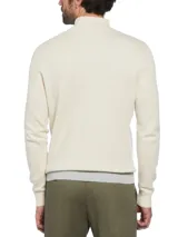 Sweater de punto color crema con franjas horizontales en verde oliva, azul y gris. Tiene cuello alto con cierre de un cuarto y logo de pingüino bordado en el pecho.