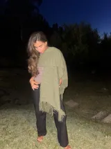 Ruana de tejido grueso color verde seco, con flecos largos en los bordes.