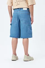 Bermuda carpenter de denim negro, corte relajado y largo a la rodilla, con costuras visibles y múltiples bolsillos funcionales.