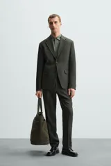 Blazer azul marino de lino con corte regular fit, cuello con solapas de muesca, manga larga con puños abotonados, bolsillo de vivo en el pecho, bolsillos de solapa en la cadera, bolsillo interior, aberturas en la espalda y cierre frontal de botonadura.
